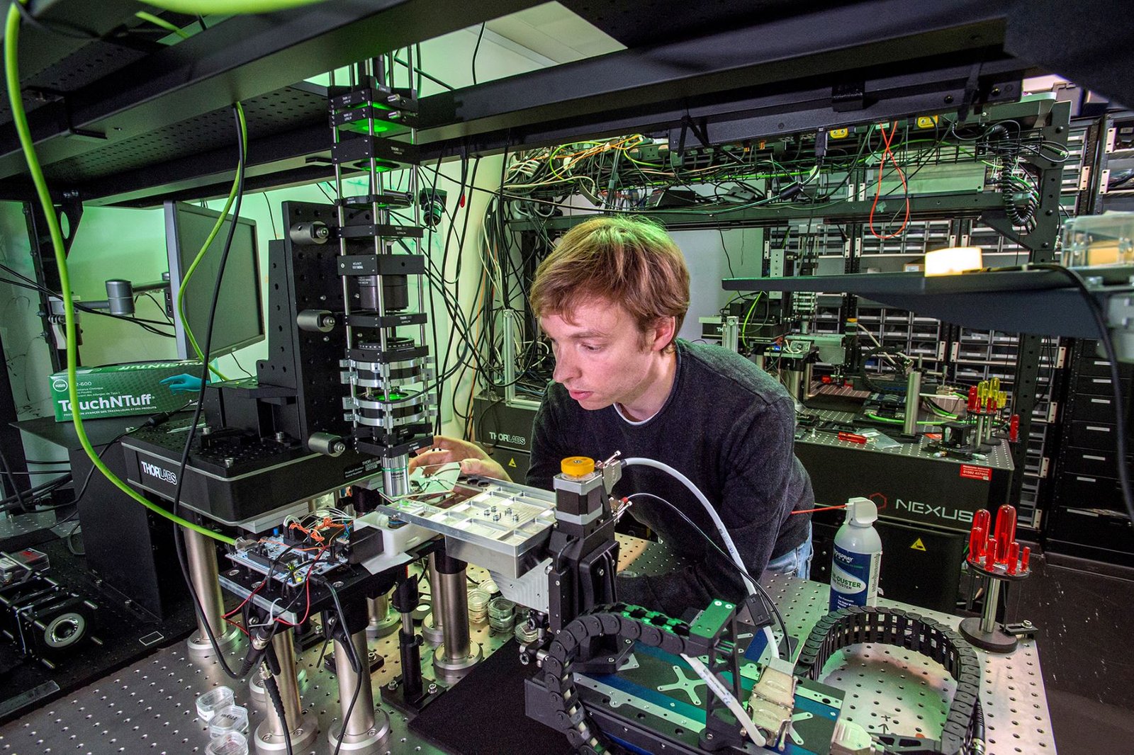 Microsoft researcher operating femtosecond laser equipment in a lab to encode data on quartz glass plates for Project Silica.