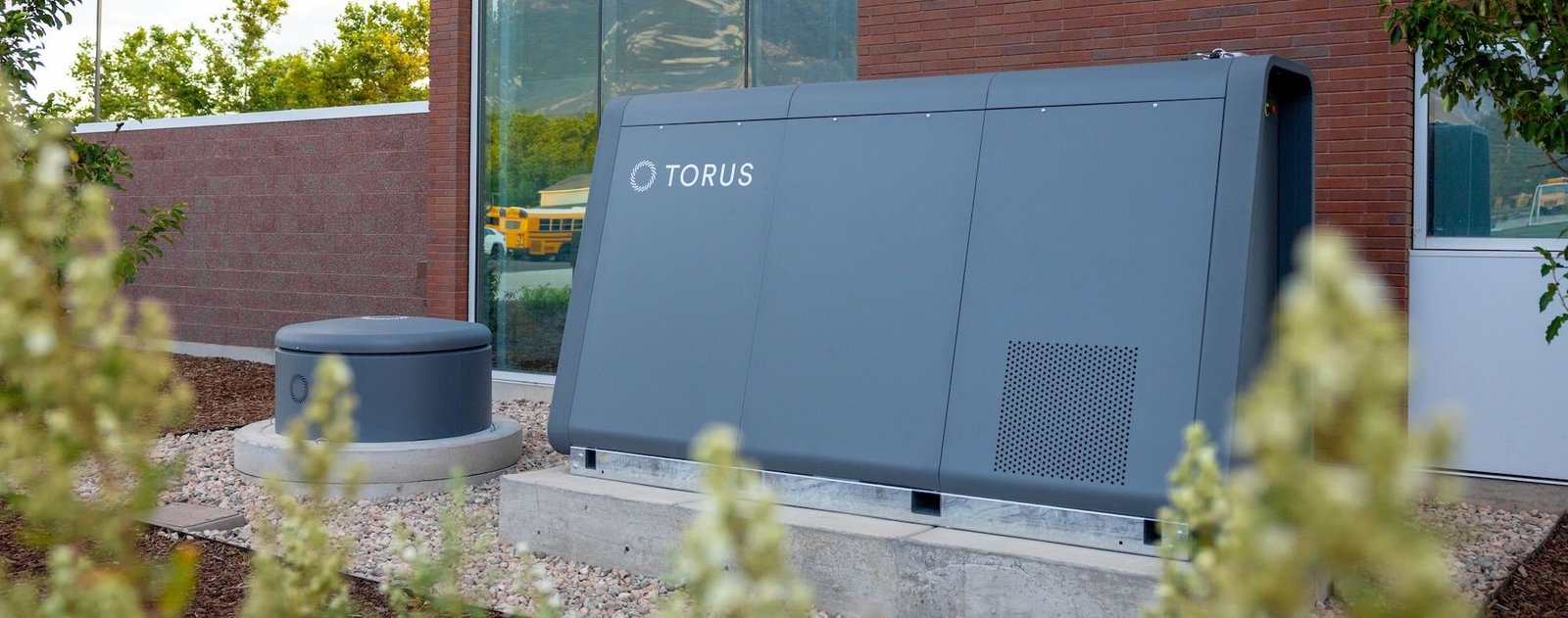 Torus hybrid flywheel-battery energy storage unit providing backup power and grid stability for a commercial building.