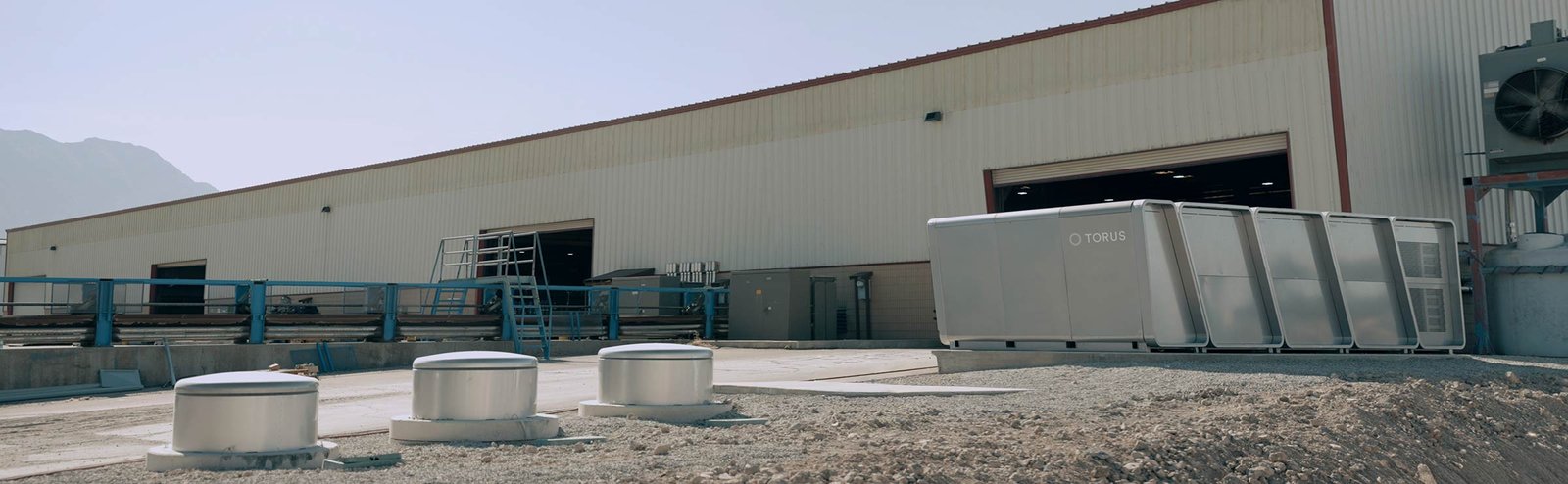 Torus hybrid flywheel-battery energy storage system installed at an industrial facility for grid support and backup power.